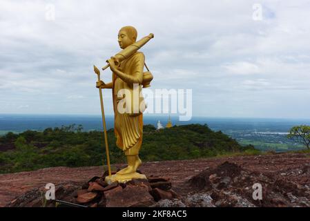 Thai buddha statue prince on top of a mountain in golden texture, with countryside background. Stock Photo