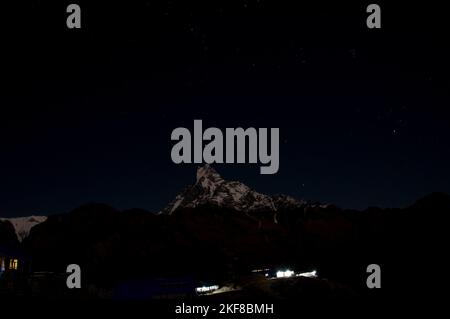 Mount Machhapuchhra (Fish Tail 6993 meters) in Himalaya mountains lit by moon. Starry sky above it Stock Photo