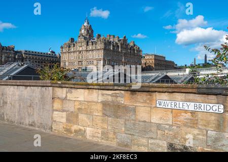 In mid-summer,blue sky.Road bridge,crossing Waverley rail station tracks,the famous hotel and Scottish Government buildings in bright sunshine,looking Stock Photo