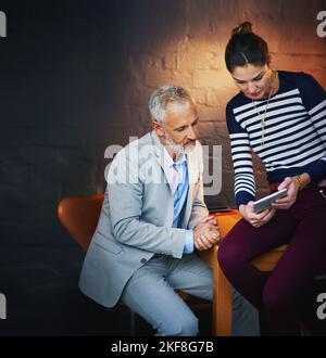 Two of the best minds on the project. coworkers using a digital tablet together. Stock Photo