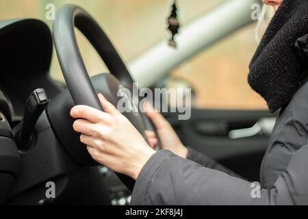 girl driving her own car in motion close-up, hands on the steering wheel Stock Photo