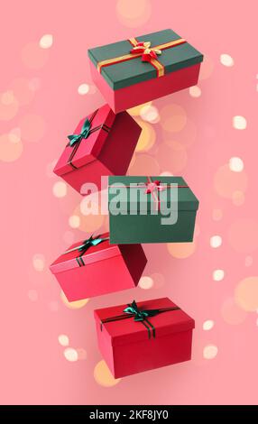 Flying Christmas gift boxes on pink background Stock Photo