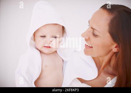 Shes Moms little angel. A baby girl wrapped in a towel and being held by her mother. Stock Photo