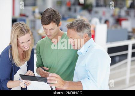 Teamwork makes the load lighter. Three work colleagues discussing something work related. Stock Photo