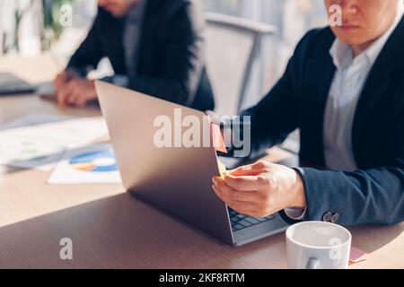 Close up of unrecognisable businessman working laptop while sitting in coworking Stock Photo