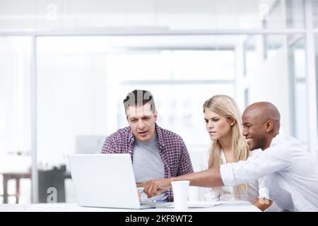 Design and Technology. Three design professionals working together on a project on a laptop. Stock Photo