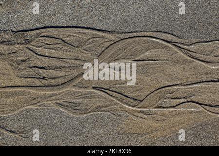 Patterns in the san formed by tidal waters, at Robin Hoods Bay , North Yorkshire, UK Stock Photo