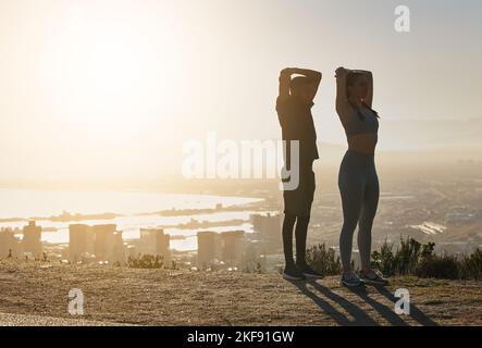 Fitness, silhouette and couple stretching in city in morning for motivation, inspiration and wellness. Sports, exercise and man and woman training Stock Photo