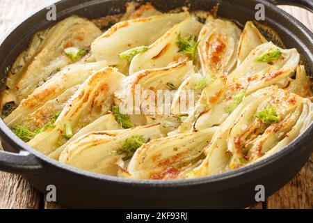Italian food Parmesan Fennel Gratin closeup on the pan on the wooden table. Horizontal Stock Photo