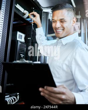 Server room, IT support and database with a man programmer working on a mainframe in a data center. Software, cyber security and innovation with a Stock Photo