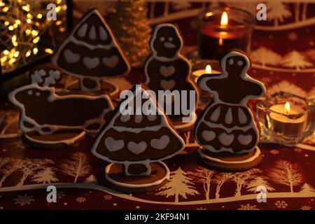 photo Christmas gingerbread with candles standing on the table in semi-darkness Stock Photo