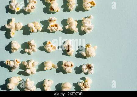 Rowes of salt popcorn on the light blue background. Stock Photo