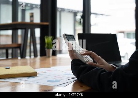 businesswoman accountant working on desk office with using a calculator to calculate the numbers, finance accounting concept Stock Photo