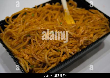 Spicy hakka noodles served in a disposable takeaway food container Stock Photo