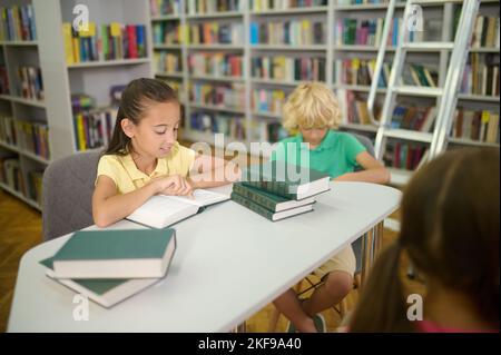 Happy classmates spending time in the school library Stock Photo