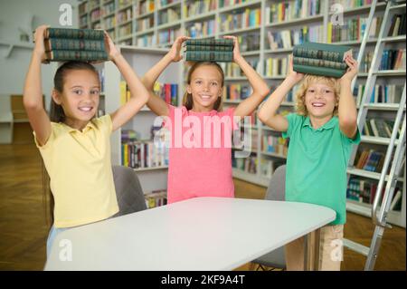 Happy classmates spending time in the school library Stock Photo