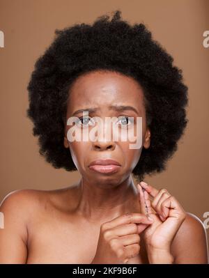 Portrait, hair and black woman in studio for problem, breakage and split ends against a brown background mockup. Afro, face and girl model unhappy Stock Photo