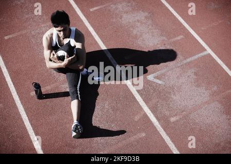 Feeling defeated. High angle view of a young runner stretching. Stock Photo