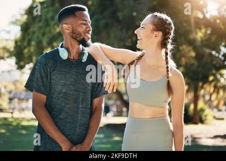 Fitness, couple and talking in nature after running, workout or exercise. Diversity, happy man and woman in discussion on break after training or Stock Photo