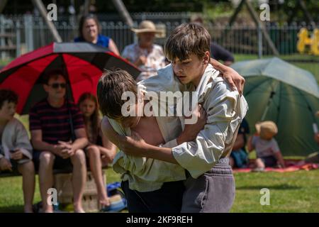 Two young teenagers brothers competing in the Grand Cornish Wrestling Tournament on the picturesque village green of St Mawgan in Pydar in Cornwall in Stock Photo