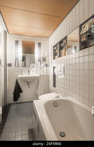 Bathroom with toilet and bathtub with tile shower in modern apartment Stock Photo