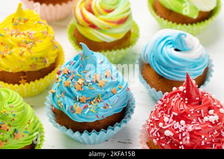 Colorful cupcakes on wooden table Stock Photo