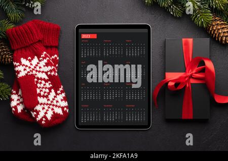 Tablet with next year calendar, gift boxes and Christmas decor. Xmas device screen template Stock Photo