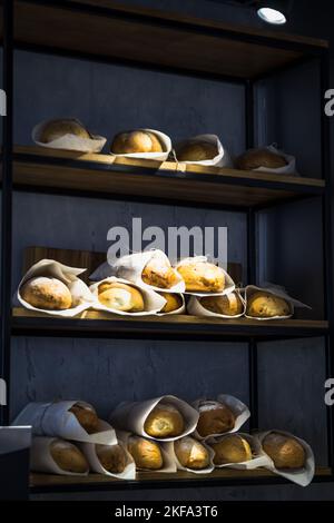 Close up bakery showcase concept photo. Craft bread store. Side view photography with french loafs on background. High quality picture for wallpaper, Stock Photo