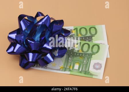 200 euros with gift ribbon. Two paper notes of a hundred euros each. A gift, a winnings, a financial aid. Stock Photo