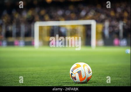 Football ball on green grass on soccer stadium in night Stock Photo
