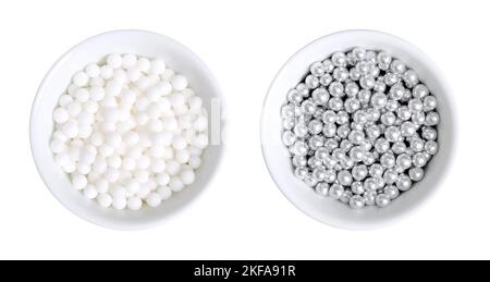 White and silver colored sugar pearls for decorating, in white bowls. Edible dragees and decorative balls, also known as love pearls. Stock Photo