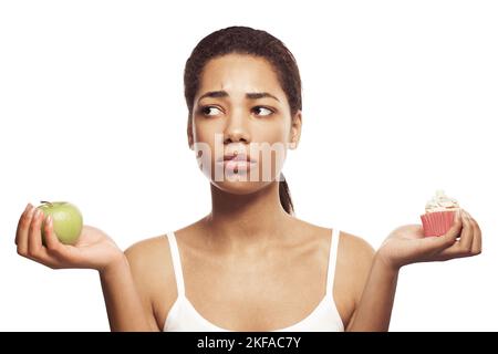 Diet. Young woman with fruit and cake portrait Stock Photo