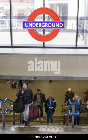 London Tube passengers coming out of Kings Cross & St. Pancras Underground Station entrance, with the sign above them, London UK Stock Photo