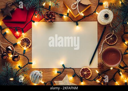 Blank paper Christmas letter to or from Santa surrounded by Christmas decorations with hot chocolate Stock Photo