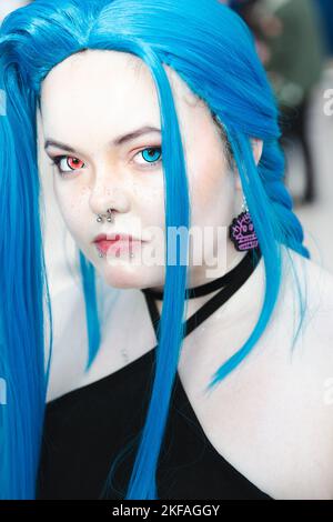 Close up portrait of a gender fluid or non binary teenager with colourful contact lenses and nose and lip piercings Stock Photo