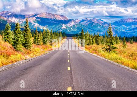Long straight road through the mountains of Denali National Park, Alaska Stock Photo
