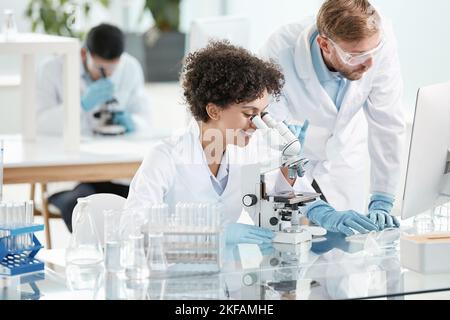 female scientist and her colleague are conducting research in the laboratory . Stock Photo