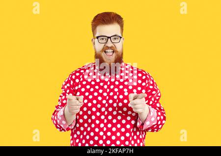 Funny happy fat bearded man in polka dot shirt and glasses smiling and pointing at camera Stock Photo