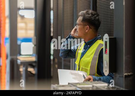 Working at warehouse. Male warehouse worker checking in storage department. Employee organizing goods distribution to the market. Stock Photo