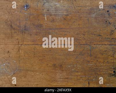 Scratches and general wear and tear are shown in detail on the surface of an old wood table. Stock Photo