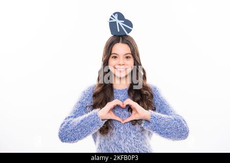 Christmas and New Year concept. Smiling teen kid girl in pink dress holding a big present gifts box on background with copy space. Stock Photo