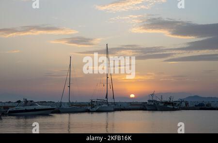 Fishing and pleasure boats at sunset in the Aegean sea in summer in Greece Stock Photo