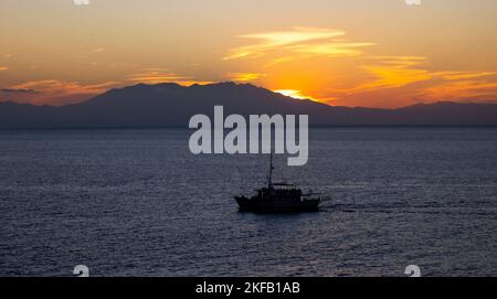 Fishing and pleasure boats at sunset in the Aegean sea in summer in Greece Stock Photo