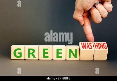 Green or greenwashing symbol. Concept words Green and Greenwashing on wooden cubes. Businessman hand. Beautiful grey table grey background. Business g Stock Photo