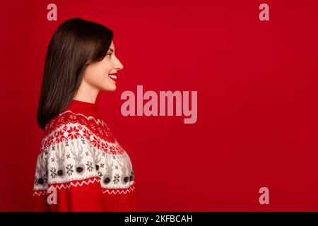 Side profile photo of pretty gorgeous satisfied girl with bob hairdo wear red sweater look empty space isolated on red color background Stock Photo