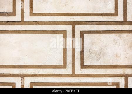 Fragment of a beige wall with a pattern in the form of brown stripes for use as an abstract background and texture. Stock Photo