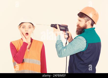 Annoying repair concept. Man with drill drills head of woman Stock Photo