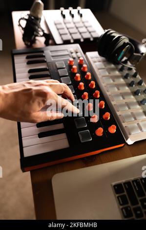 Musician's hand on midi keyboard, synthesizer. Recording studio, music studio, radio, music school, home studio. Close-up. Advertising, banner, invita Stock Photo