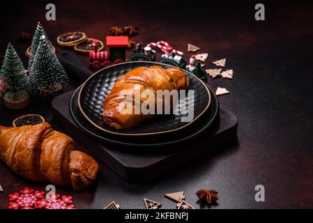 Beautiful different Christmas decorations and croissant on a brown concrete table. Preparation for New Year's celebrations Stock Photo