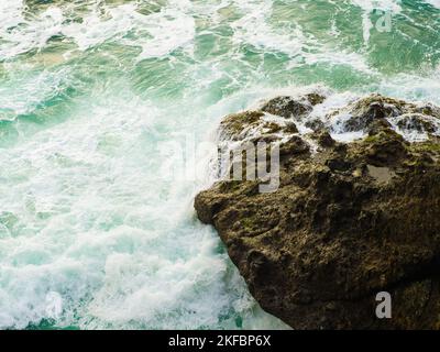 Seascape. Big boulder in the ocean. Foamy waves crash against the stone. Storm, element. Fresh sea air, ecologically clean place, environmental protec Stock Photo